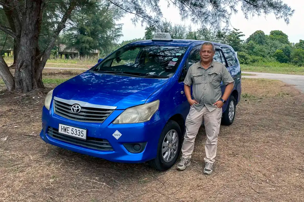 Anuar standing beside the My Little Taxi Toyota Innova used for meeting and site transport in Malaysia